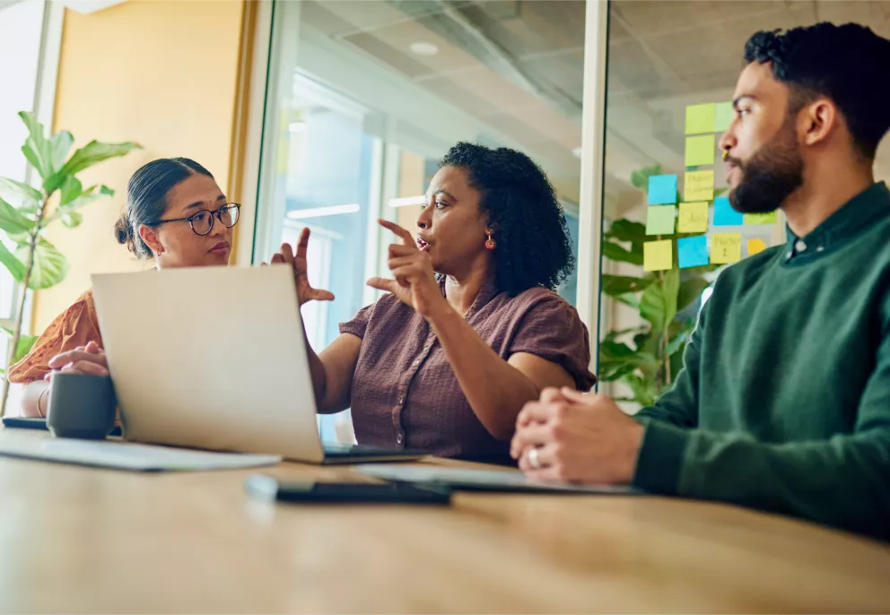 Tres personas conversando en un entorno de oficina sobre las tendencias de investigación de mercado